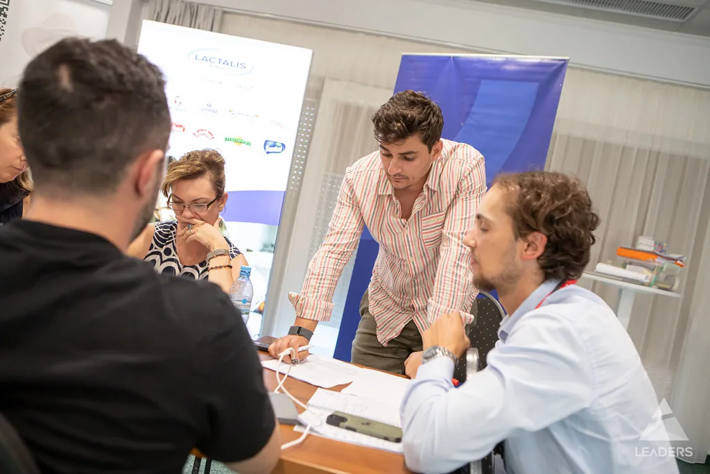 Leaders Challenge participants debating and building a solution together around a workshop table