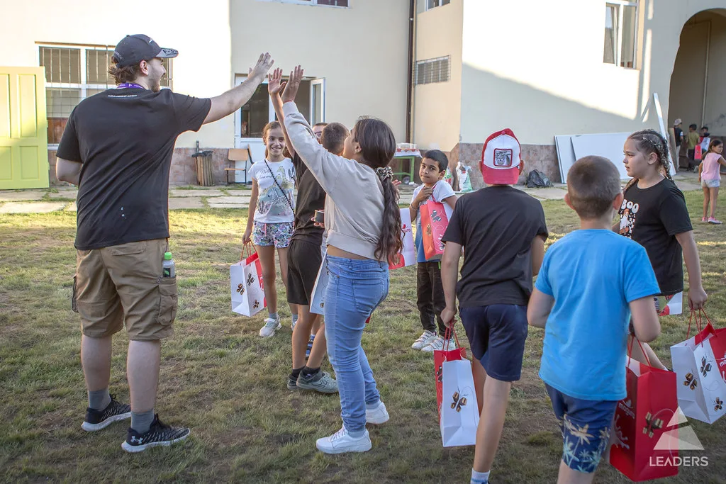 Leadership School participant celebrating with children during a community activity in Sibiu